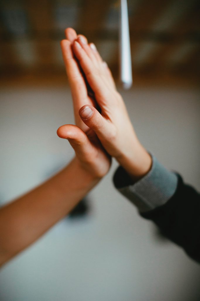 두 손으로 하이파이브를 하는 것은 성공적인 파트너십을 축하하는 의미입니다.